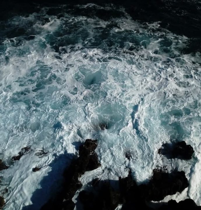 Foto del mare che si infrange sugli scogli